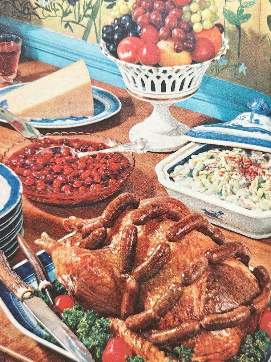 Vintage recipes featuring a bizarre sausage-wrapped turkey with classic side dishes and a bowl of fresh fruit on a decorated table.