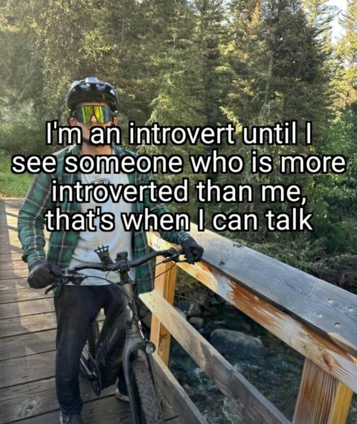 Man wearing helmet and sunglasses with bicycle on wooden bridge, introvert meme text about talking to others more introverted.