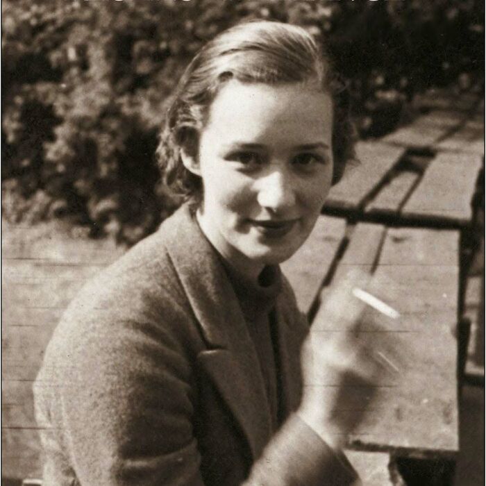 Black and white photo of a woman smiling outdoors, representing women overlooked in history and their achievements.