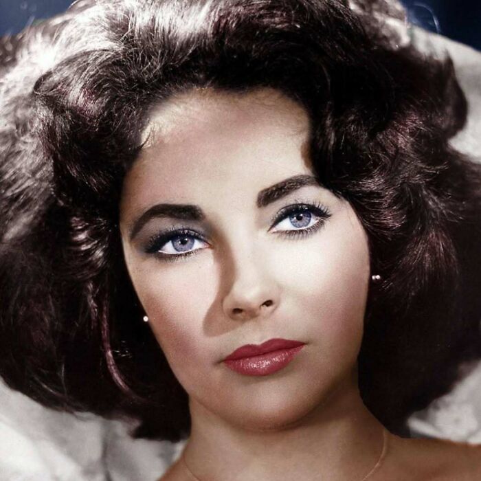 Portrait of a woman with striking blue eyes and dark hair, representing overlooked women in history and their achievements.