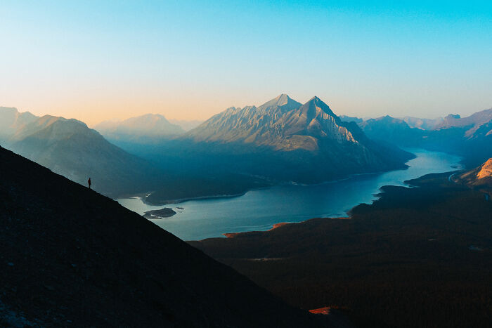 A lone hiker on a mountain slope overlooking a lake and distant peaks, symbolizing purpose and self-discovery. A lone hiker on a mountain slope overlooking a lake and distant peaks, symbolizing purpose and self-discovery.