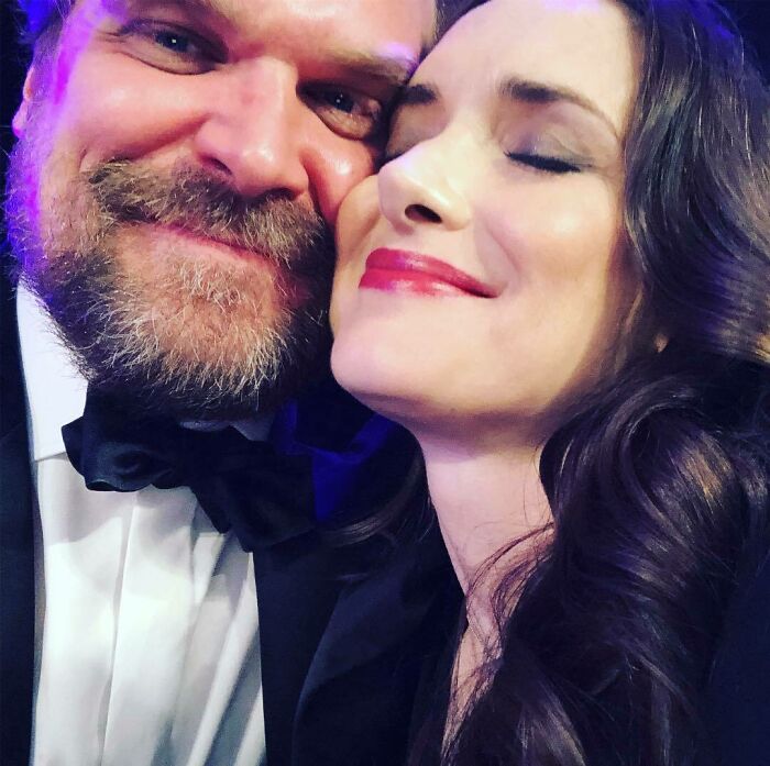 David Harbour and Stranger Things co-star close together, smiling and showing affection at a formal event. David Harbour and Stranger Things co-star close together, smiling and showing affection at a formal event.