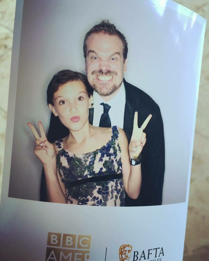Millie Bobby Brown and David Harbour posing playfully together at a BBC America and BAFTA event.