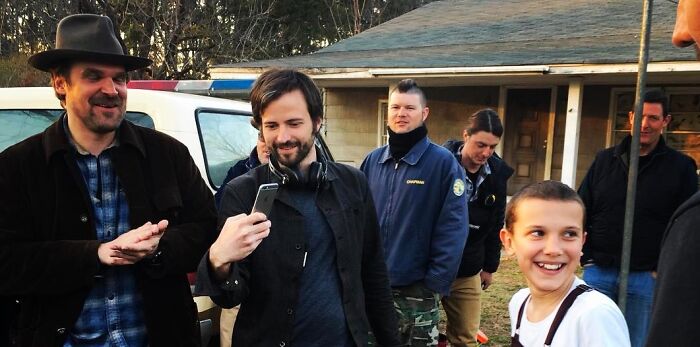 Millie Bobby Brown and David Harbour on set, showcasing their complex relationship amid recent harassment allegations.