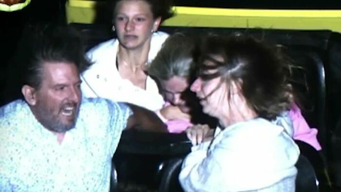Couple assisting terrified girl on roller coaster after seat belt pops open during 205-foot drop ride.