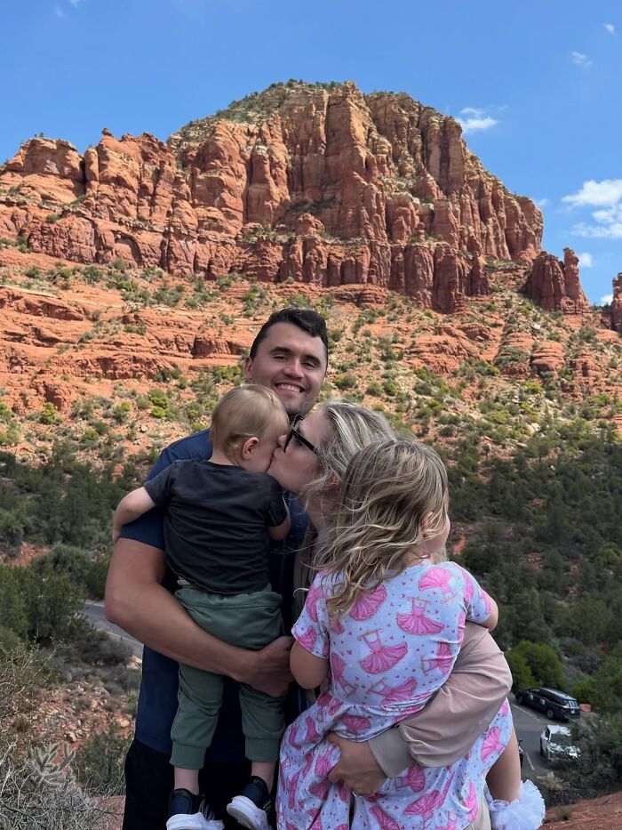 Family embracing outdoors by red rock cliffs, illustrating emotional exchange as revealed by lip reader at TPUSA event. Family embracing outdoors by red rock cliffs, illustrating emotional exchange as revealed by lip reader at TPUSA event.