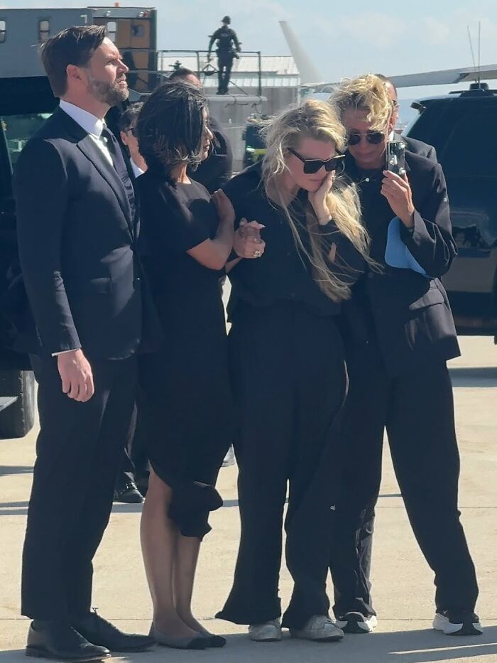 Erika Kirk and others in black outfits sharing an emotional moment, highlighting lip reader exchange at TPUSA event. Erika Kirk and others in black outfits sharing an emotional moment, highlighting lip reader exchange at TPUSA event.