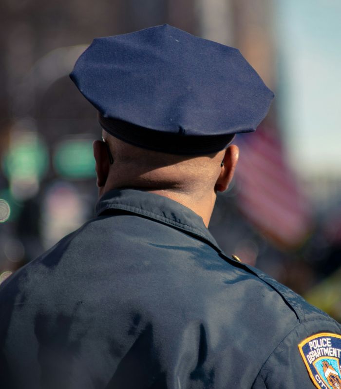 Police officer from behind wearing uniform and cap, involved in investigation of woman found chained in backyard case. Police officer from behind wearing uniform and cap, involved in investigation of woman found chained in backyard case.