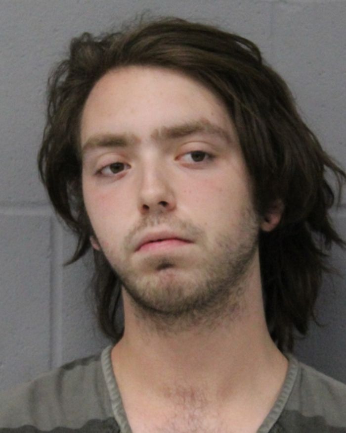 Mugshot of a young man with unkempt hair and a somber expression linked to woman found chained in backyard case. Mugshot of a young man with unkempt hair and a somber expression linked to woman found chained in backyard case.