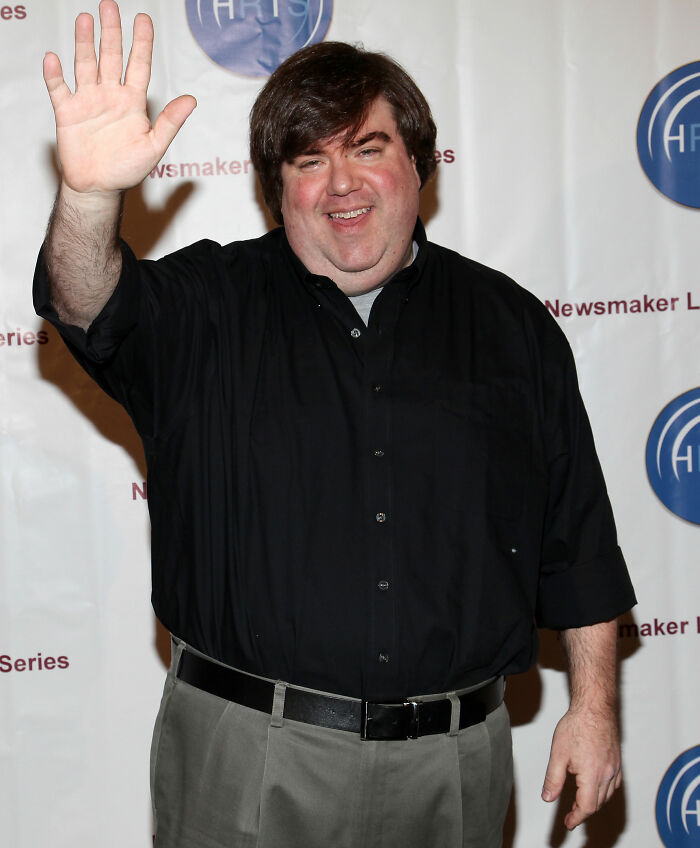 Man in black shirt waving and smiling at event, related to Amanda Bynes breaking silence after claim against Dan Schneider. Man in black shirt waving and smiling at event, related to Amanda Bynes breaking silence after claim against Dan Schneider.