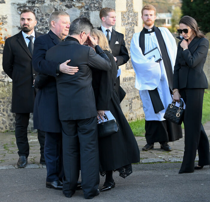 Mourners dressed in black at a solemn outdoor gathering, related to Simon Cowell and Liam Payne mental health discussion. Mourners dressed in black at a solemn outdoor gathering, related to Simon Cowell and Liam Payne mental health discussion.