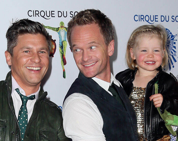 Neil Patrick Harris with a smiling young girl and another man at a Cirque du Soleil event. Neil Patrick Harris with a smiling young girl and another man at a Cirque du Soleil event.