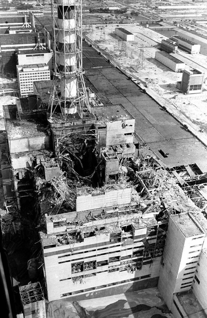 Aerial view of a heavily damaged industrial building showing the dark aftermath of a catastrophic event.