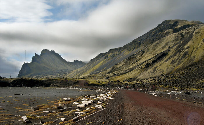 Remote rugged landscape with rocky mountains and a dirt path, showcasing mind-blowing remote locations that actually exist.