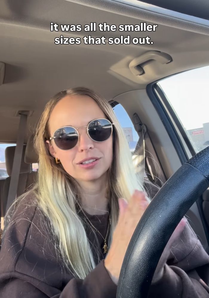 Woman with sunglasses sitting in a car discussing smaller sizes selling out of more revealing sacred underwear for Mormon women.