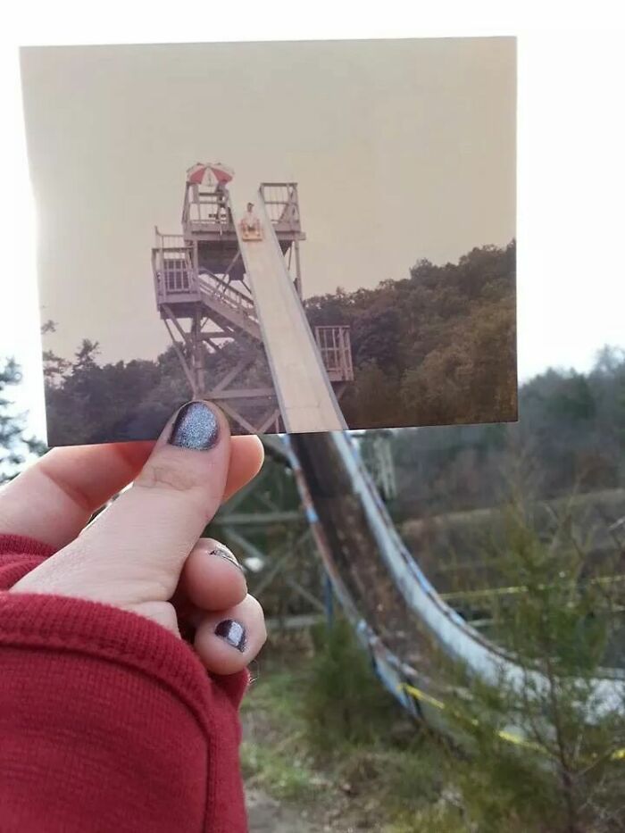 Hand holding a photo perfectly aligned with a water slide in the background showing things aligned so perfectly.