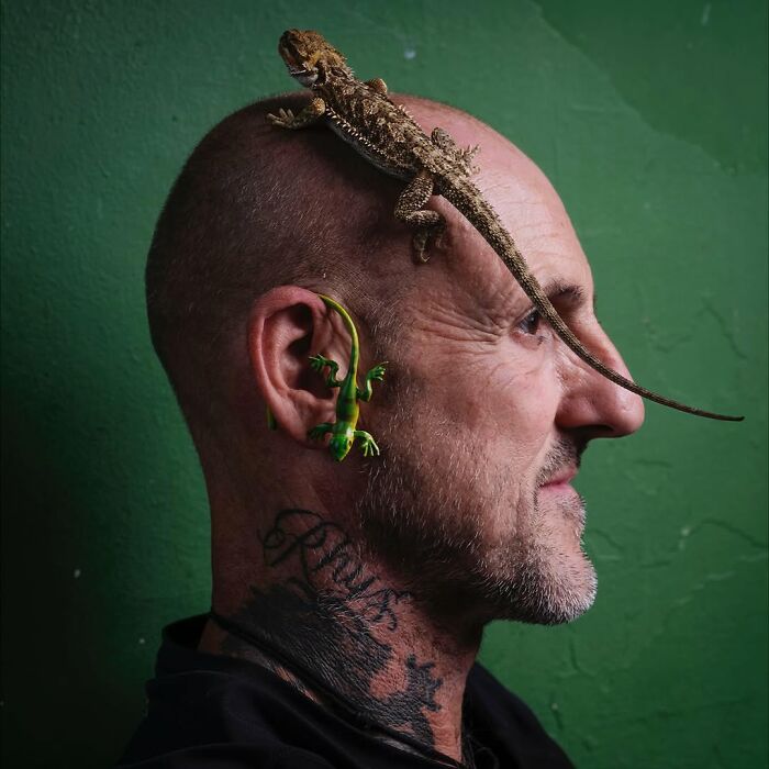 Man with two lizards on his head and ear, showing pets and their humans looking shockingly alike.