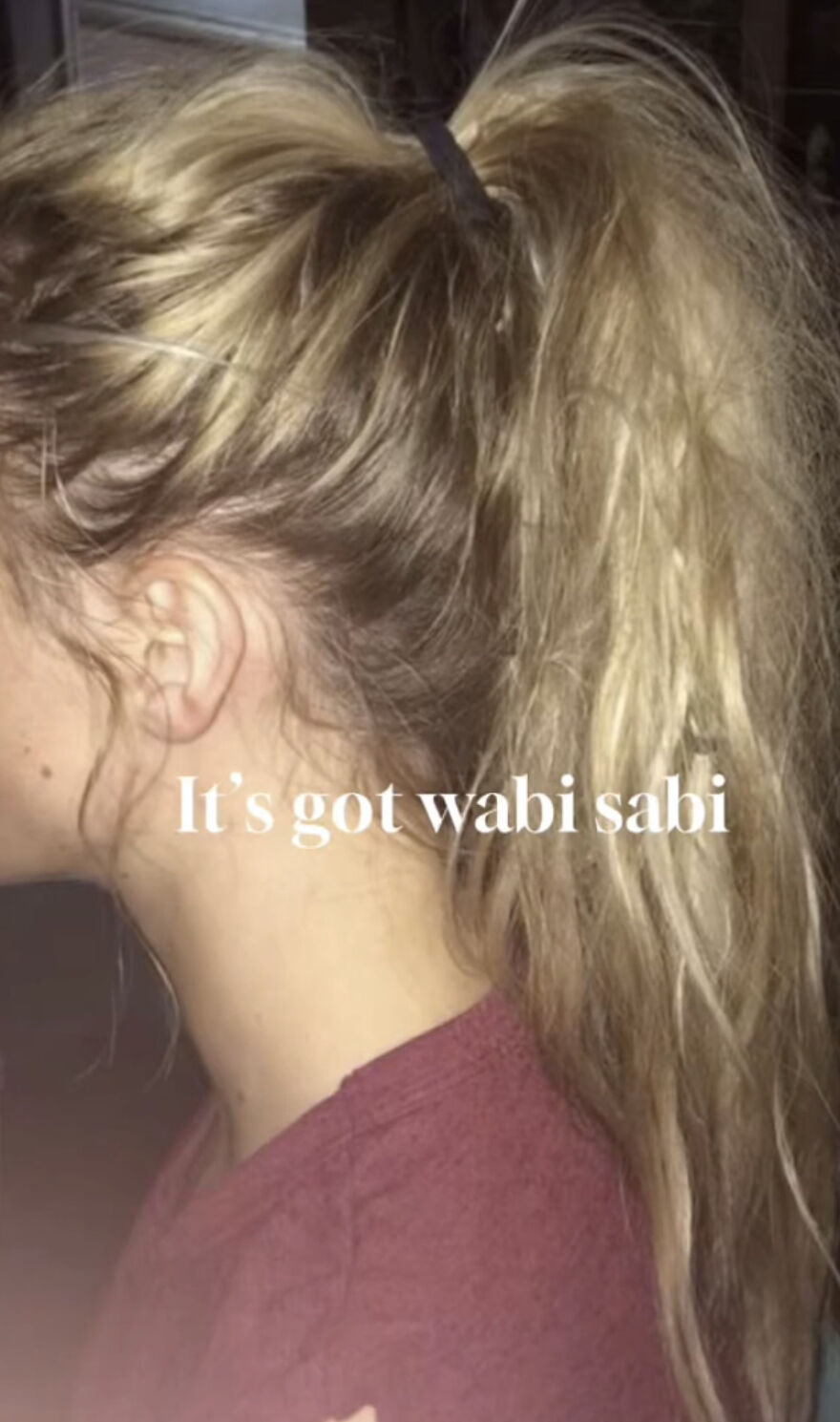 Young woman with messy blonde ponytail embracing perfect imperfections in a wholesome trend of self-acceptance.