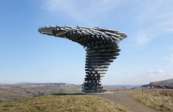Large outdoor metal sculpture composed of pipes on a hilltop, a spectacular sculpture for travel bucket list.