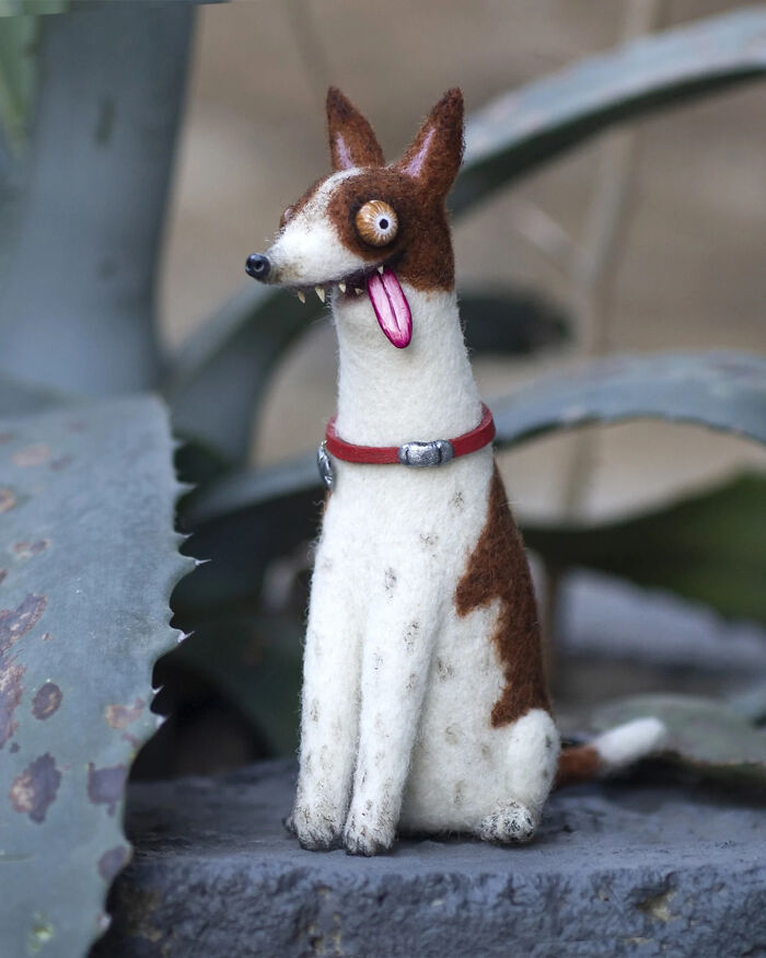 Handmade creature toy resembling a quirky dog with a red collar, featuring adorably strange and unique design details.