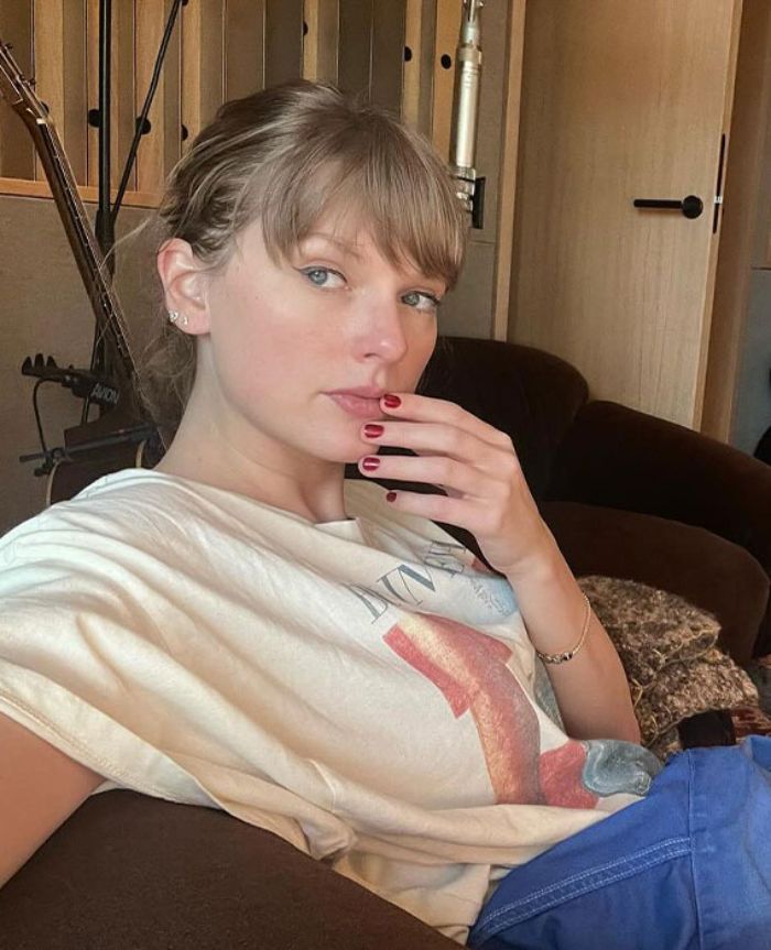 Taylor Swift sitting casually indoors with hand near face, linked to an embarrassing video sparking debate about her manners. Taylor Swift sitting casually indoors with hand near face, linked to an embarrassing video sparking debate about her manners.