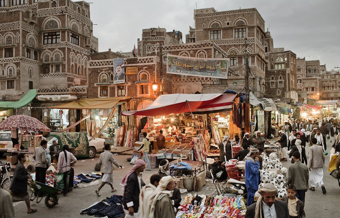 Busy market scene in one of the poorest countries in the world, showing people amid traditional buildings and street vendors.