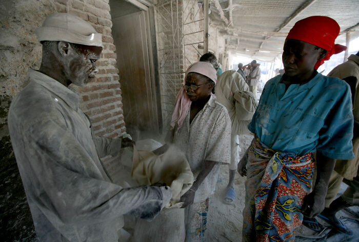 People working in a dusty environment in one of the poorest countries in the world facing economic hardship.
