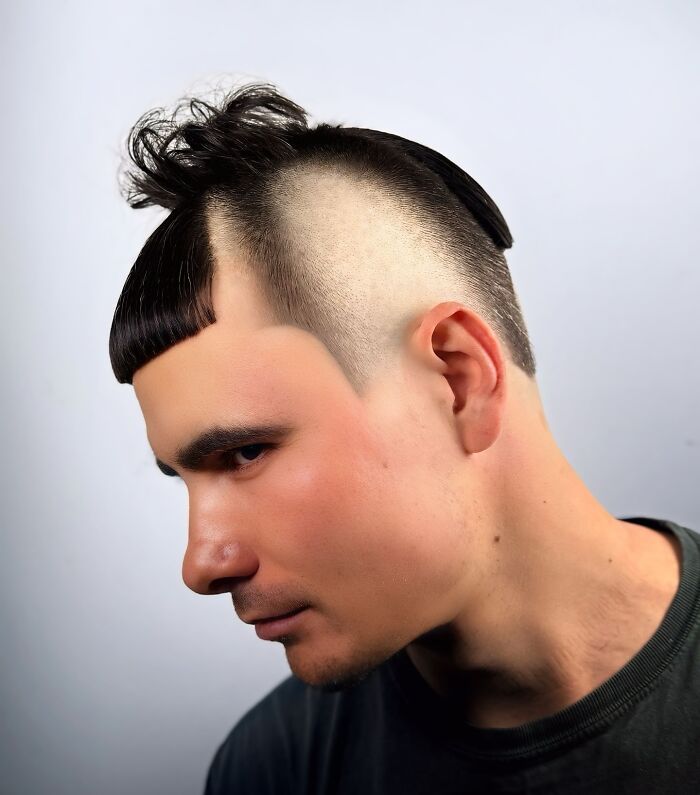 Young man with a bold barber haircut featuring shaved sides and a unique textured fringe hairstyle.