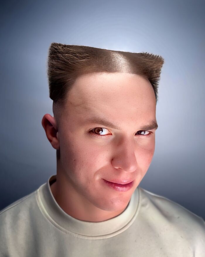 Young man with a bold barber haircut featuring sharp, flat-top styled hair on the sides and top against a plain background.