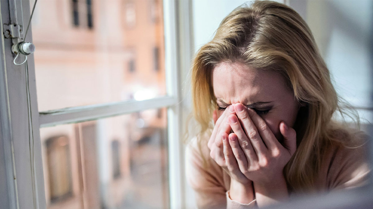 Woman upset by adoptive parents while wanting to reunite with her biological family in an emotional moment by a window