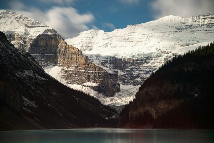 Snow-covered mountains towering over a serene lake, illustrating the beauty often found in craziest coincidences nature reveals.