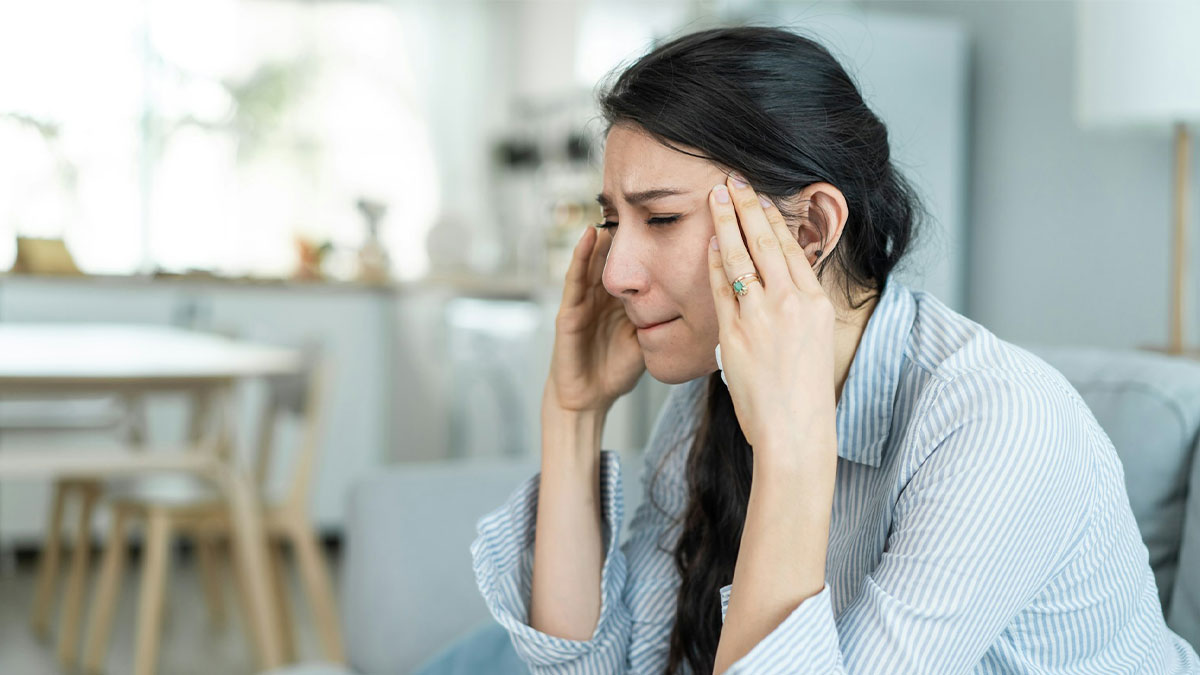 Woman looking upset and stressed at home, reacting to sister not giving her the remade wedding dress.