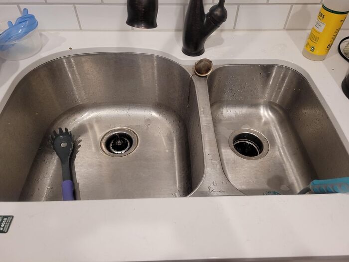 Double stainless steel kitchen sink with black faucet and cooking utensils, highlighting great things about the US lifestyle.