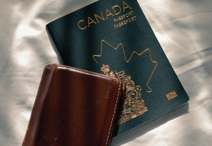 Canadian passport with brown leather wallet, symbolizing American expats adjusting to life and culture in Canada.
