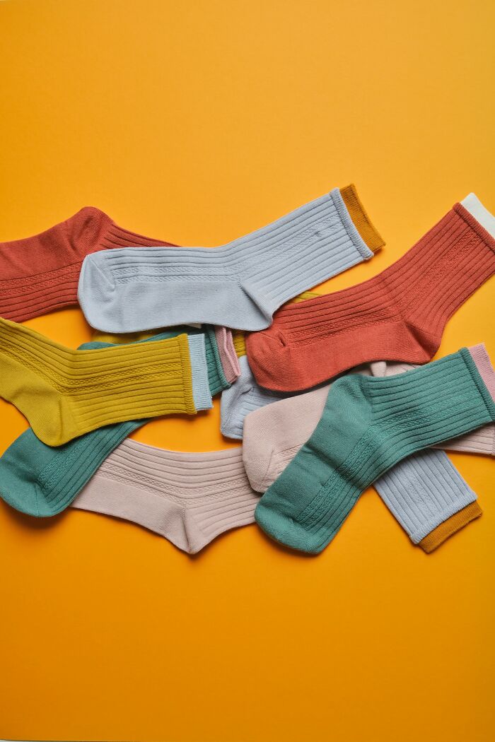 Colorful socks scattered on an orange background, illustrating childhood habits that were anything but normal.