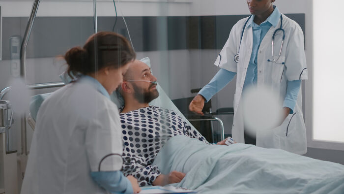 Patient in hospital bed interacting with doctors, illustrating strange things patients said or did under anesthesia effects.