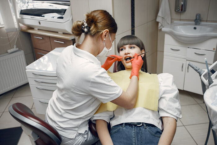 Dentist examining a patient in a dental chair, illustrating unusual patient behavior under the effects of anesthesia.
