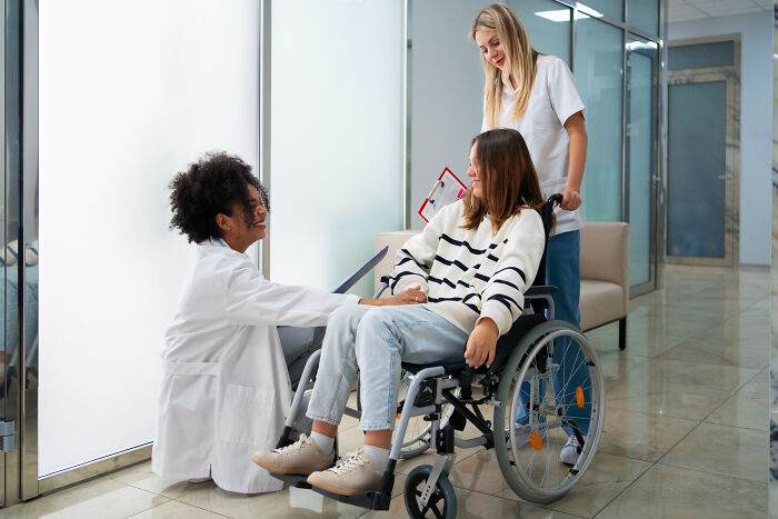 Patient in wheelchair interacting with medical staff, illustrating surprising patient behavior under anesthesia effects.