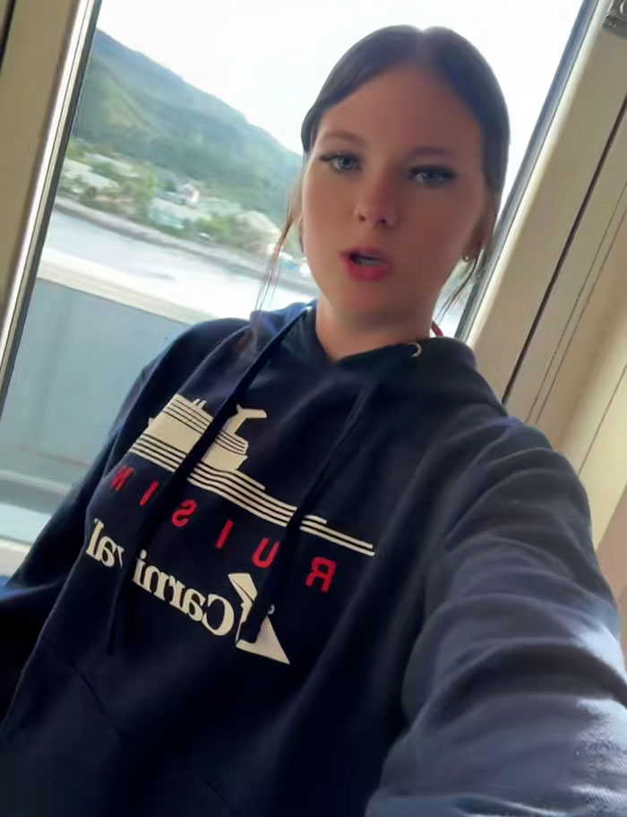 Teen wearing cruise hoodie near window with water and hills, related to stepbrother obsessed with her disturbing details case. Teen wearing cruise hoodie near window with water and hills, related to stepbrother obsessed with her disturbing details case.