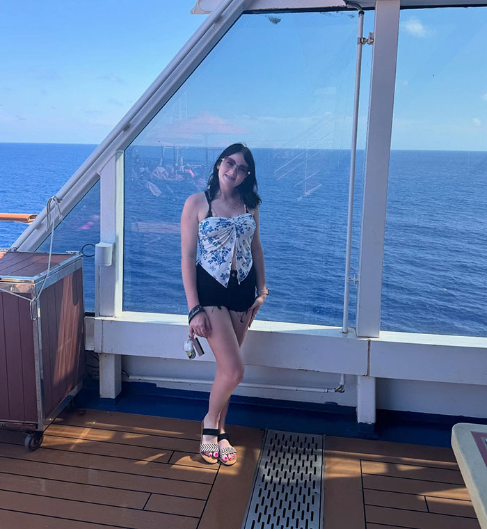 Teen on Carnival cruise ship deck with ocean background related to stepsibling investigation after body found under bed Teen on Carnival cruise ship deck with ocean background related to stepsibling investigation after body found under bed