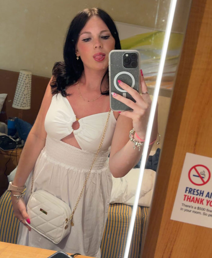 Young woman taking mirror selfie in white dress, stepsibling under investigation after teen’s body found on Carnival Cruise. Young woman taking mirror selfie in white dress, stepsibling under investigation after teen’s body found on Carnival Cruise.