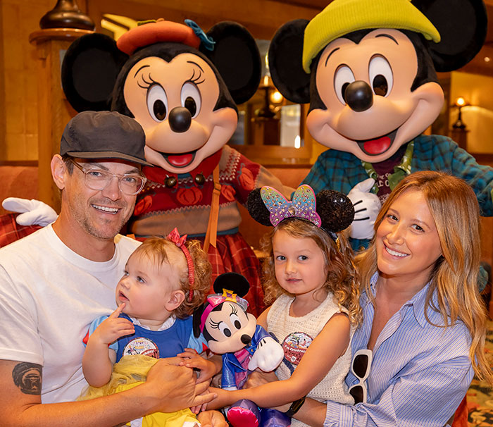 Ashley Tisdale with family at a theme park, smiling and holding children, highlighting Ashley Tisdale name change news. Ashley Tisdale with family at a theme park, smiling and holding children, highlighting Ashley Tisdale name change news.