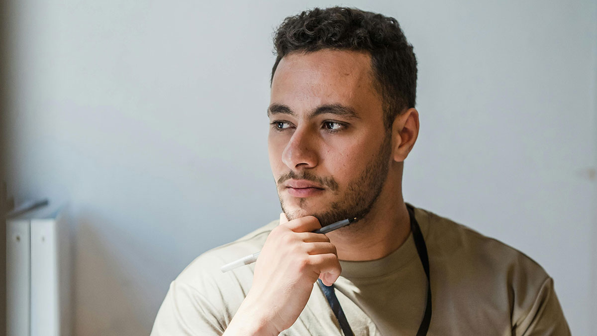 Thoughtful man considering if he should ask employee about pregnancy in a right to fire work environment.