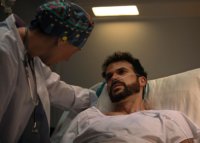 Doctor comforting a male patient in hospital bed, highlighting wild family dramas that make relatives seem normal.