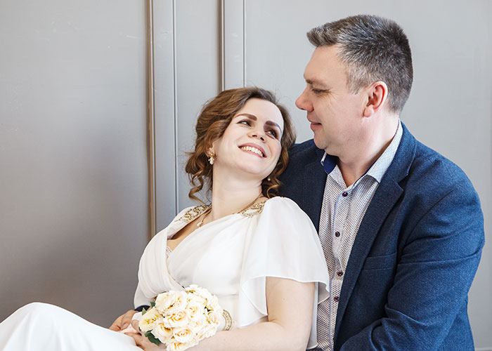 Smiling couple in wedding attire sharing a tender moment, illustrating wild family dramas making relatives seem normal.