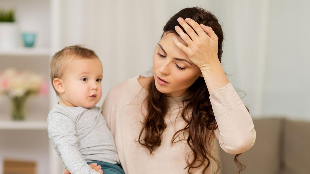 Theme park worker looking worried while holding an unknown baby indoors, parents vanished into crowd situation.