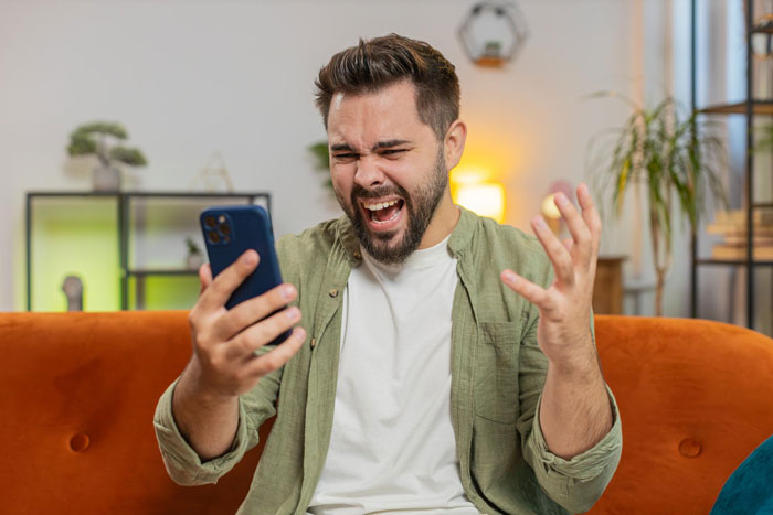 Man angrily shouting at phone while sitting on orange couch, illustrating guy cheating and demanding babysit his affair child. Man angrily shouting at phone while sitting on orange couch, illustrating guy cheating and demanding babysit his affair child.