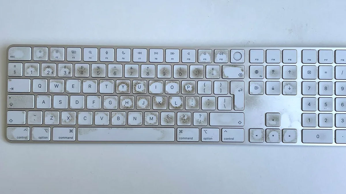 Dirty white keyboard covered in grime and dust showing before cleaning in satisfying before and after cleaning photos.
