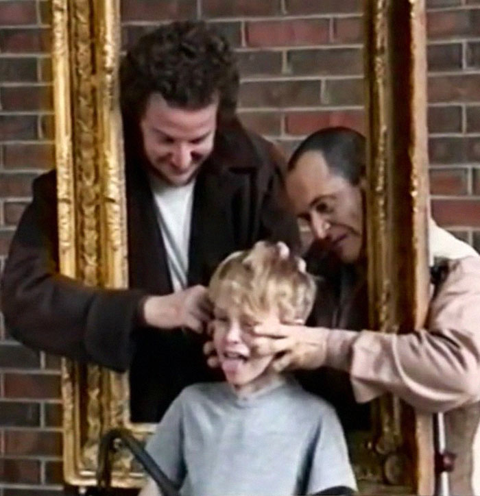 Behind-the-scenes photo of actors goofing around with a picture frame creating a funny unhinged moment.