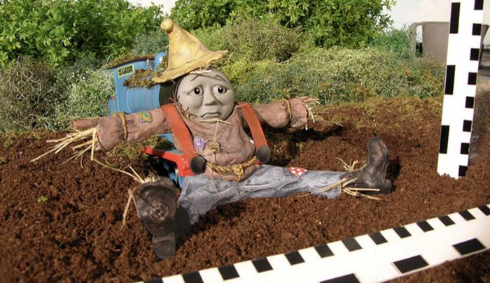 Behind-the-scenes photo of a puppet scarecrow character sitting in soil, showcasing unhinged and meme-worthy moments.